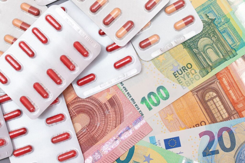 Una imagen con varios billetes y blisters de pastillas