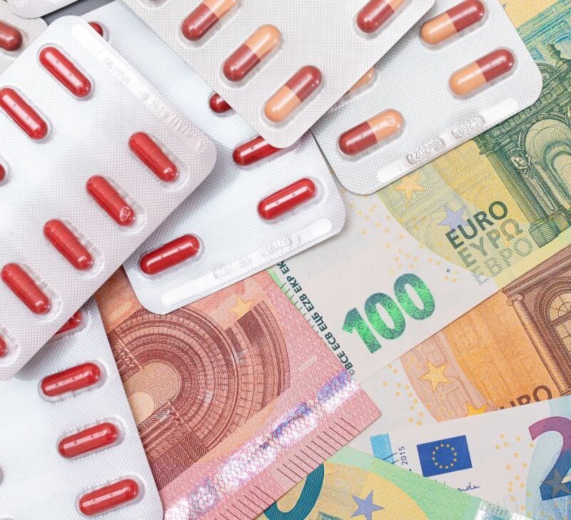 Una imagen con varios billetes y blisters de pastillas